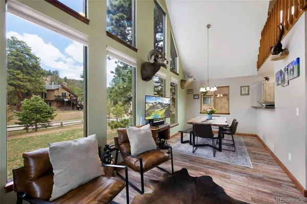 a living room with furniture a fireplace and a floor to ceiling window
