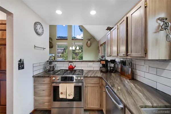 a kitchen with stainless steel appliances granite countertop a sink and a stove