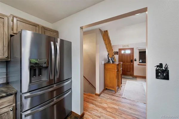 a kitchen with stainless steel appliances a refrigerator and wooden floor