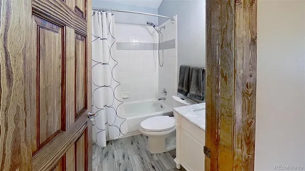 a bathroom with a granite countertop sink a toilet and shower