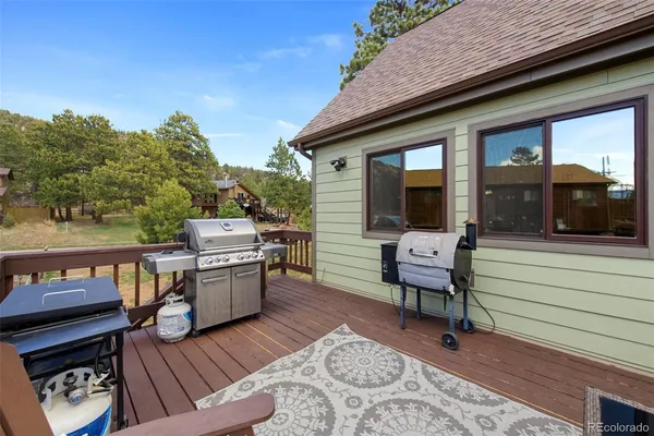 a view of a patio with table and chairs with wooden floor and fence