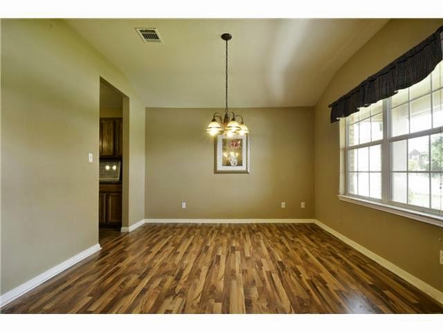 11612 Timber Heights Drive Austin, TX 78754 - Photo 11 of 28 A refined dining room with rich hardwood flooring and a stylish chandelier creates an inviting atmosphere.