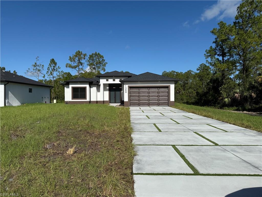 a view of a white house with a yard and potted plants