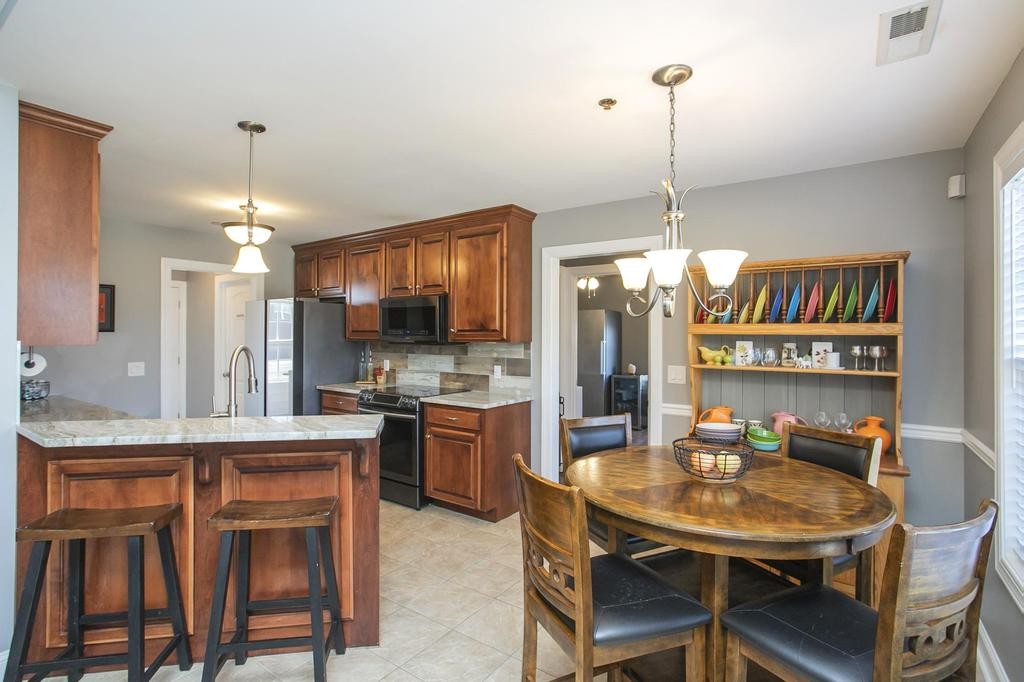 110 Edgewater Falls Murfreesboro, TN 37129 - Photo 12 of 31 a kitchen with a dining table chairs stainless steel appliances and cabinets