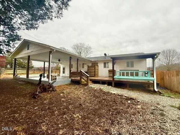 a view of a house with a yard and wooden fence