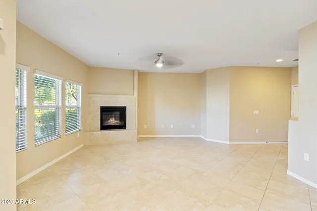 a view of an empty room with a fireplace and a window