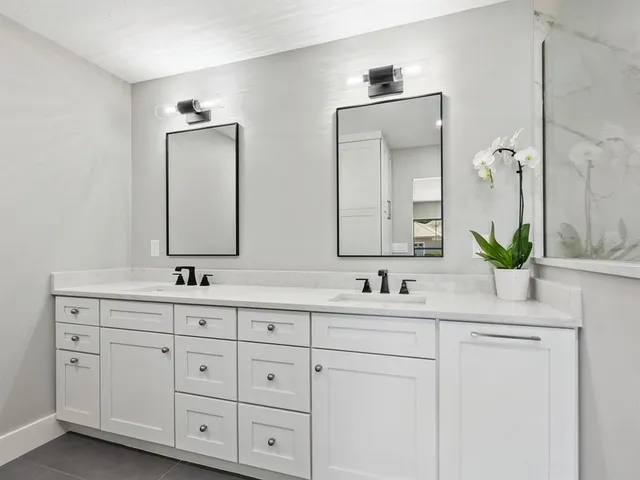 a bathroom with a granite countertop sink a toilet and a mirror