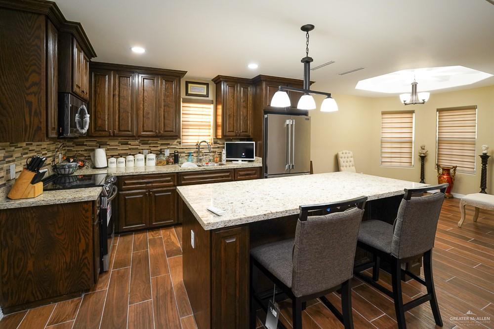 1408 Royola Street Mission, TX 78572 - Photo 11 of 42 a kitchen with center island table and chairs in it