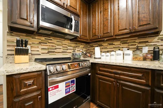 a kitchen with stainless steel appliances granite countertop a stove and a microwave