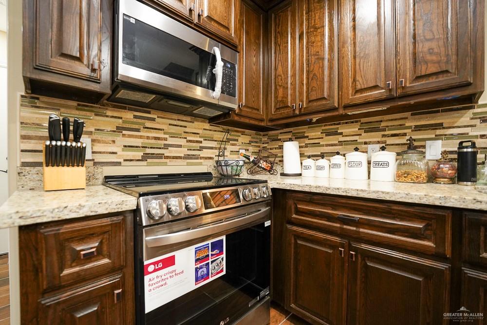 1408 Royola Street Mission, TX 78572 - Photo 14 of 42 a kitchen with stainless steel appliances granite countertop a stove and a microwave