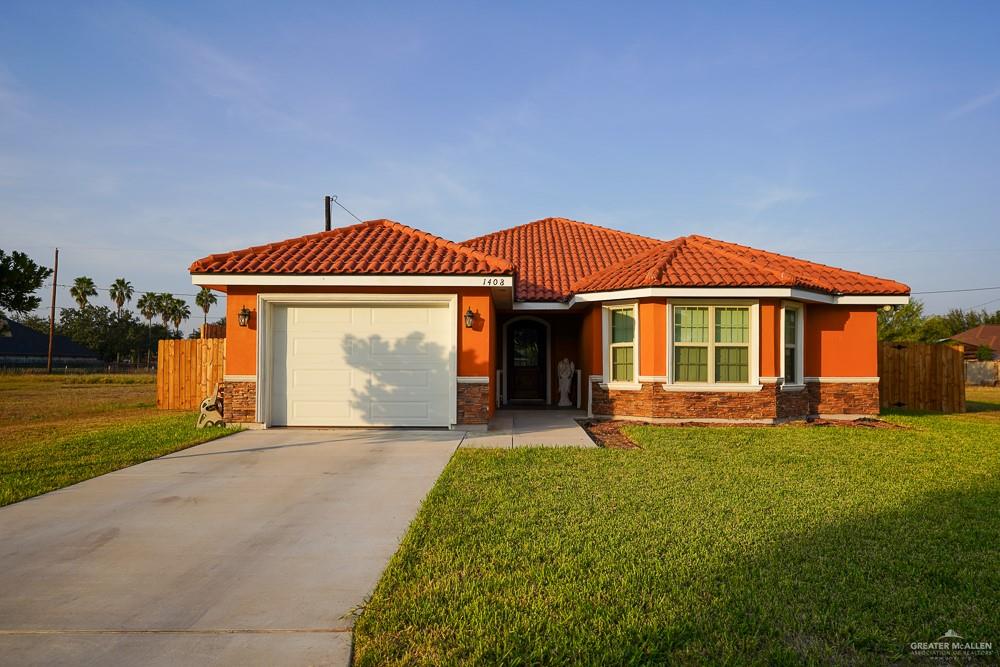 1408 Royola Street Mission, TX 78572 - Photo 2 of 42 a front view of a house with garden