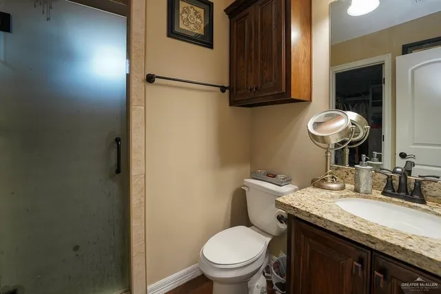 a bathroom with a granite countertop toilet sink and mirror