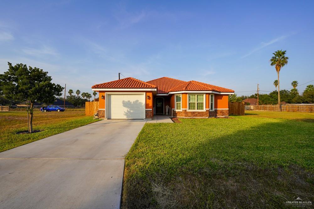1408 Royola Street Mission, TX 78572 - Photo 4 of 42 a front view of a house with a yard