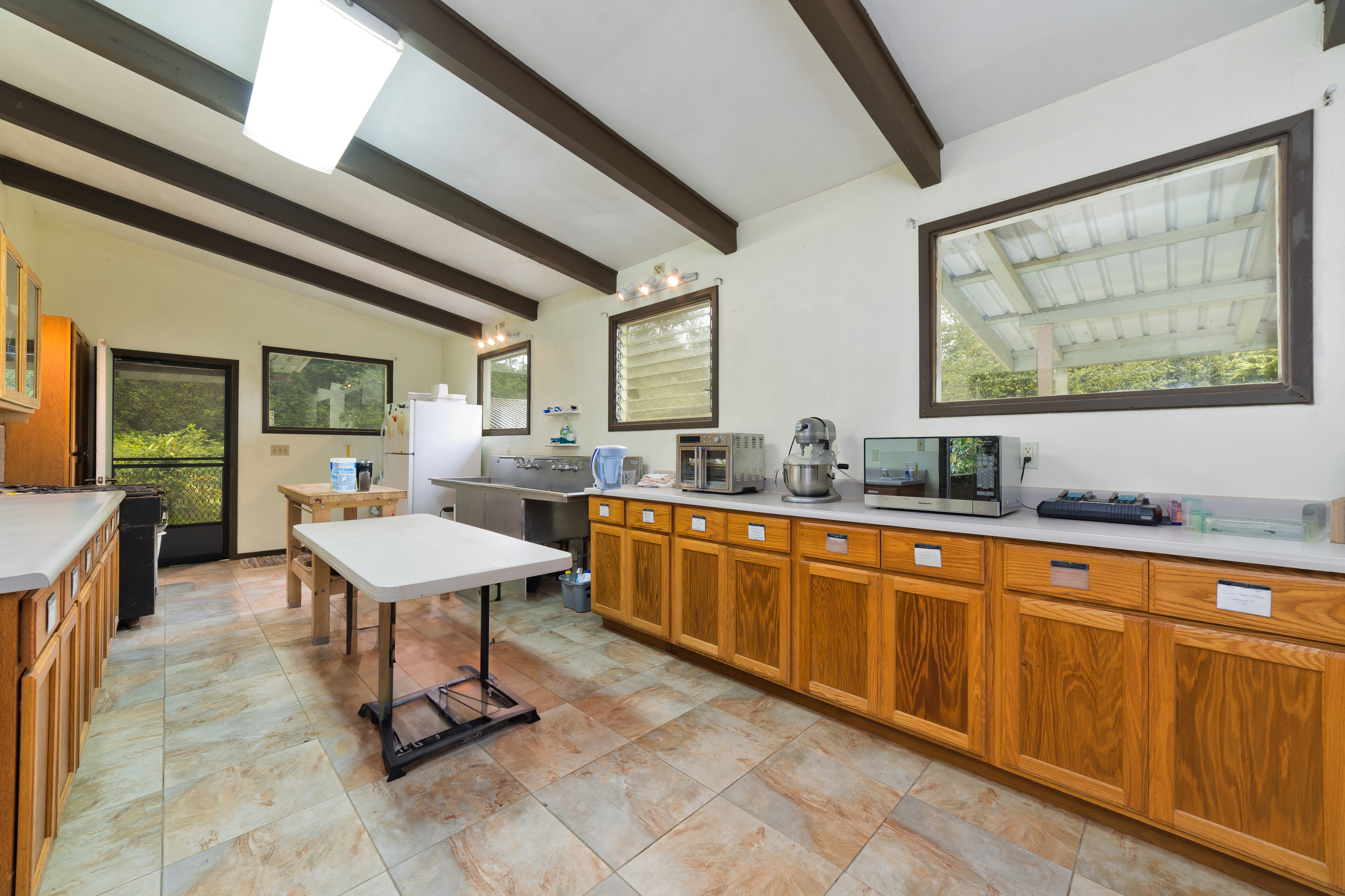 44-3342 Kula Kahiko Road Paauilo, HI 96776 - Photo 10 of 30 a dining hall with stainless steel appliances granite countertop a stove a sink dishwasher and cabinets with wooden floor