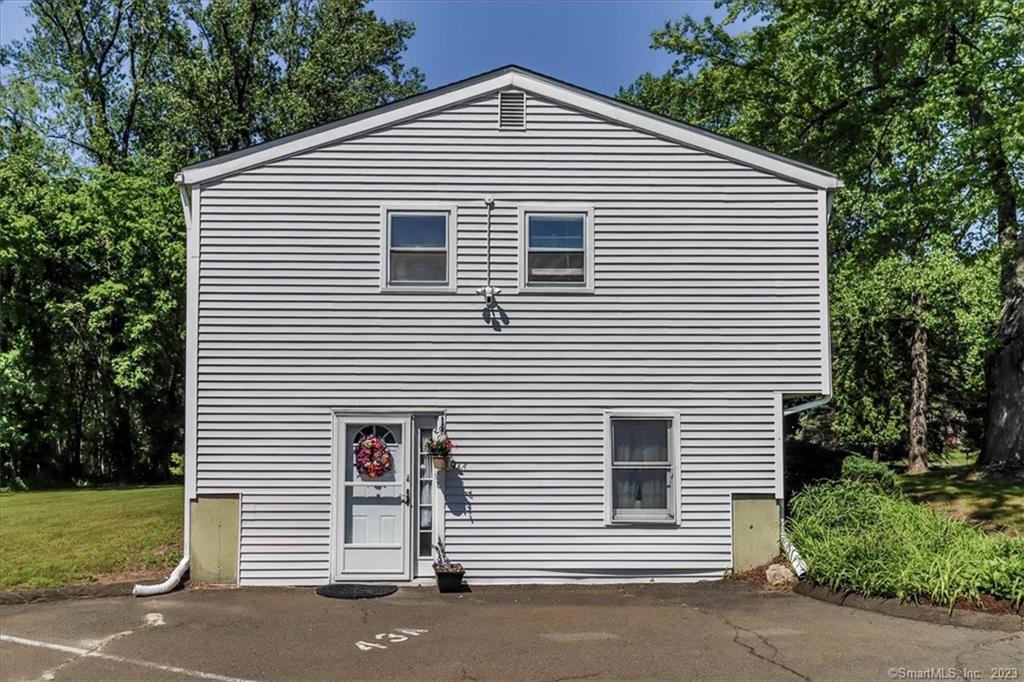 43 Plumtrees Road, Unit A Bethel, CT 06801 - Photo 1 of 1 a view of a white house next to a yard and large trees