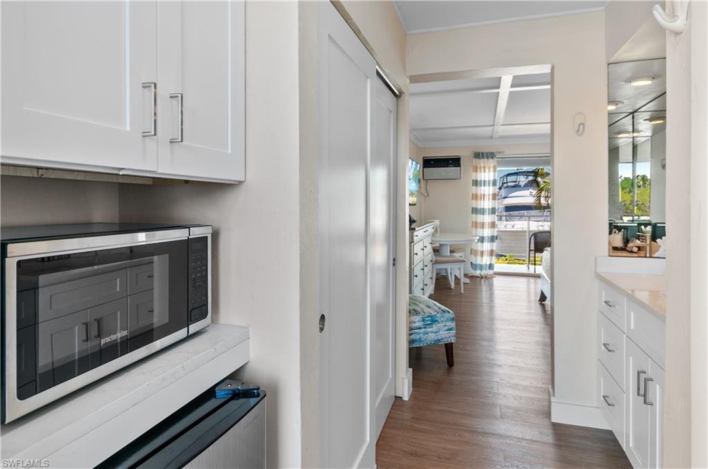 900 Broad Avenue South, Unit 133/134 Naples, FL 34102 - Photo 17 of 37 a kitchen with white cabinets and appliances