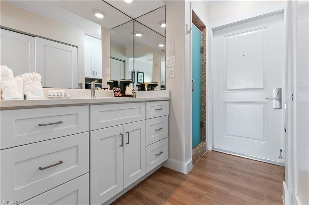 900 Broad Avenue South, Unit 133/134 Naples, FL 34102 - Photo 18 of 37 a bathroom with a double vanity sink and mirror