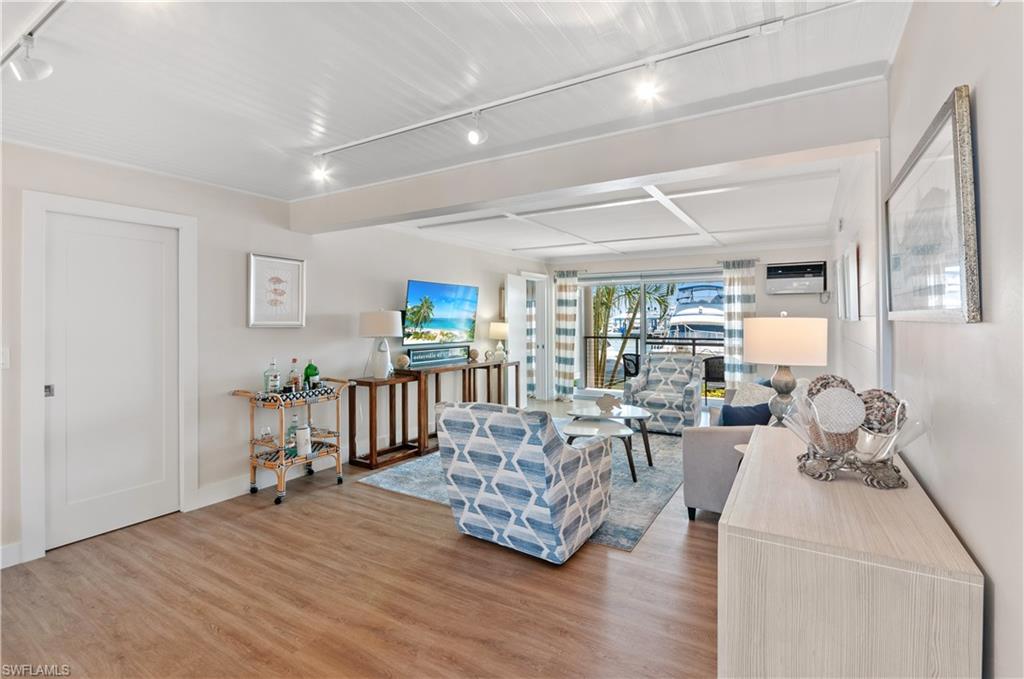 900 Broad Avenue South, Unit 133/134 Naples, FL 34102 - Photo 2 of 37 a living room with furniture and a wooden floor