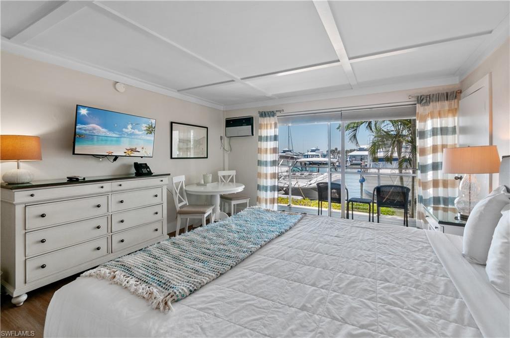 900 Broad Avenue South, Unit 133/134 Naples, FL 34102 - Photo 30 of 37 a living room with furniture and a flat screen tv