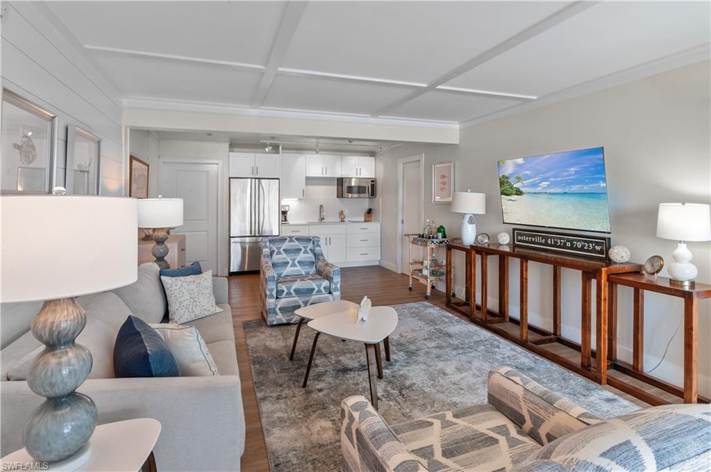 900 Broad Avenue South, Unit 133/134 Naples, FL 34102 - Photo 4 of 37 a living room with furniture and a wooden floor