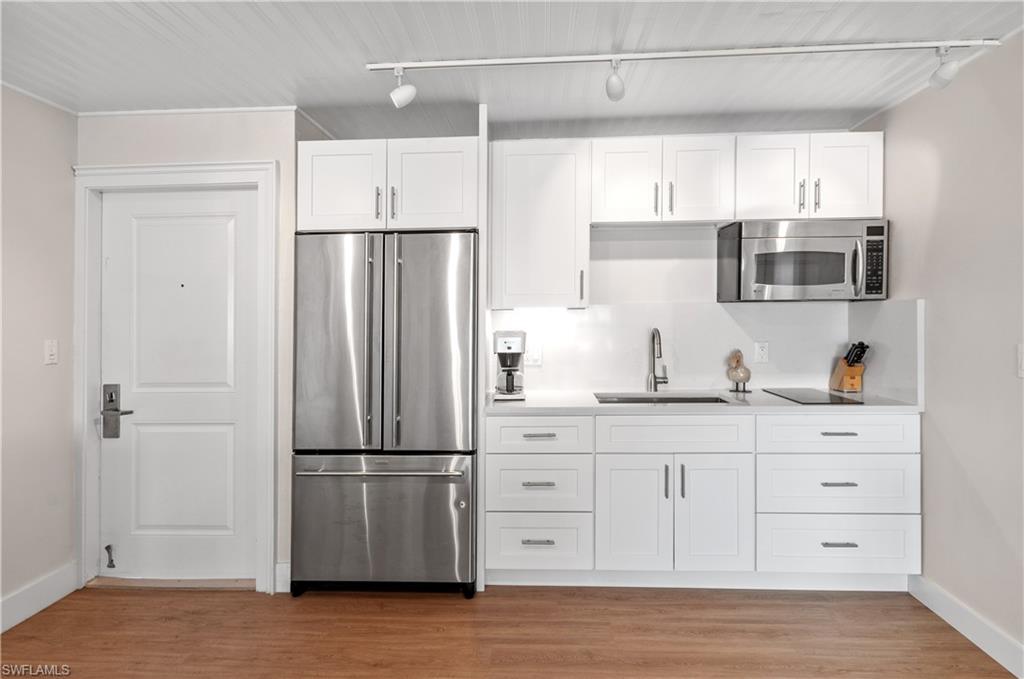 900 Broad Avenue South, Unit 133/134 Naples, FL 34102 - Photo 5 of 37 a kitchen with stainless steel appliances a refrigerator sink and cabinets