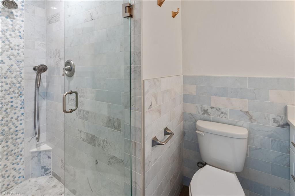 900 Broad Avenue South, Unit 133/134 Naples, FL 34102 - Photo 7 of 37 a bathroom with a toilet and shower