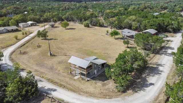 an aerial view of a house with a yard and trees