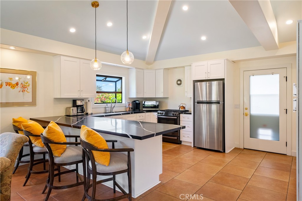 204 18th Street Paso Robles, CA 93446 - Photo 11 of 65 a kitchen with stainless steel appliances granite countertop a dining table chairs refrigerator and microwave