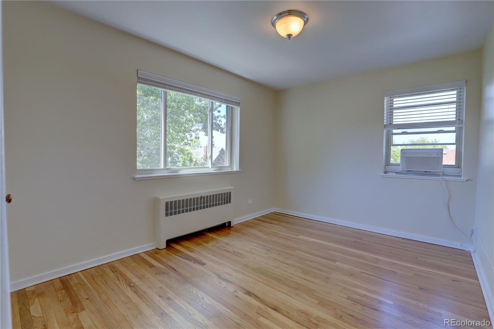 2100 Franklin Street, Unit 8 Denver, CO 80205 - Photo 15 of 29 an empty room with wooden floor and windows