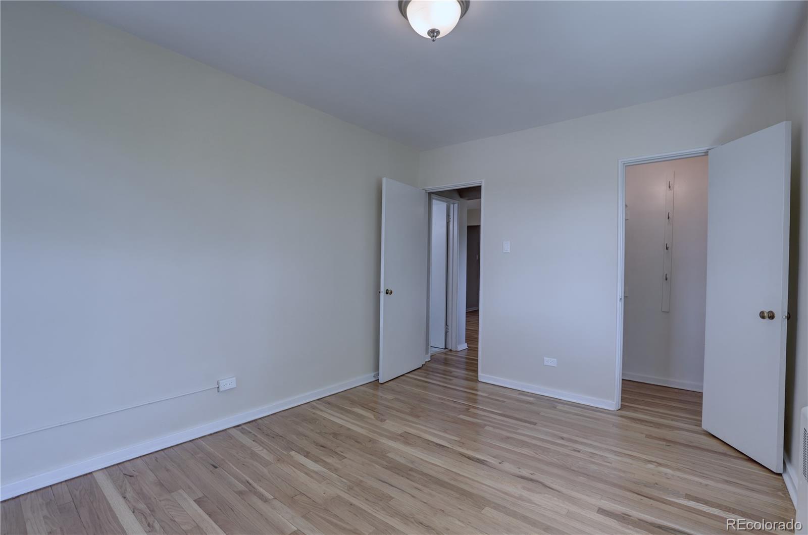 2100 Franklin Street, Unit 8 Denver, CO 80205 - Photo 16 of 29 a view of an empty room with wooden floor and closet