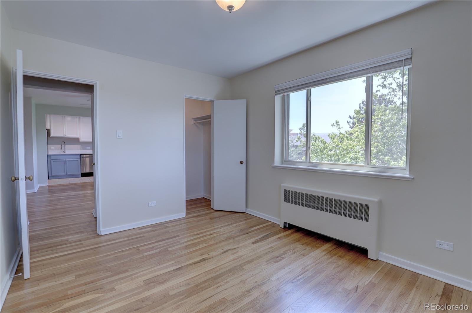 2100 Franklin Street, Unit 8 Denver, CO 80205 - Photo 17 of 29 a view of an empty room with wooden floor and a window
