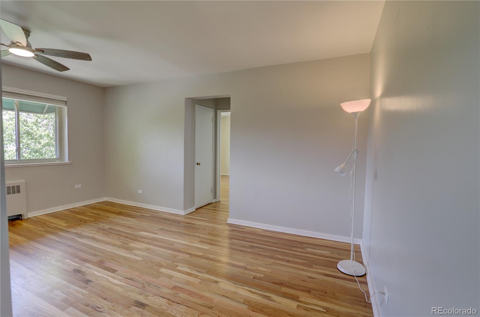 2100 Franklin Street, Unit 8 Denver, CO 80205 - Photo 6 of 29 a view of an empty room with wooden floor and a window