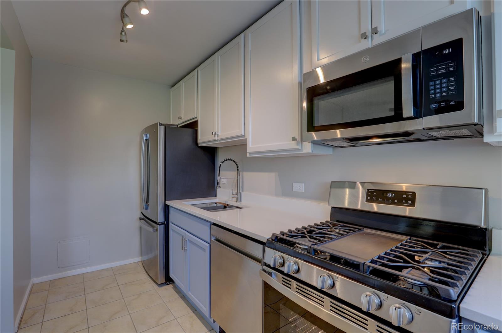 2100 Franklin Street, Unit 8 Denver, CO 80205 - Photo 8 of 29 a kitchen with stainless steel appliances granite countertop a stove and a microwave
