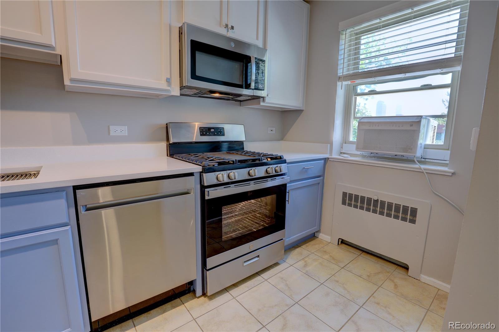 2100 Franklin Street, Unit 8 Denver, CO 80205 - Photo 9 of 29 a kitchen with white cabinets and appliances