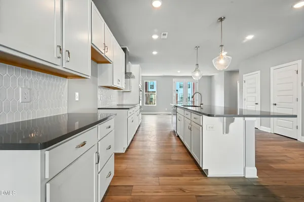 a large kitchen with cabinets and wooden floor