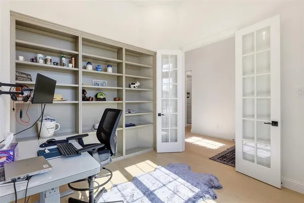 a view of a workspace with furniture and a window