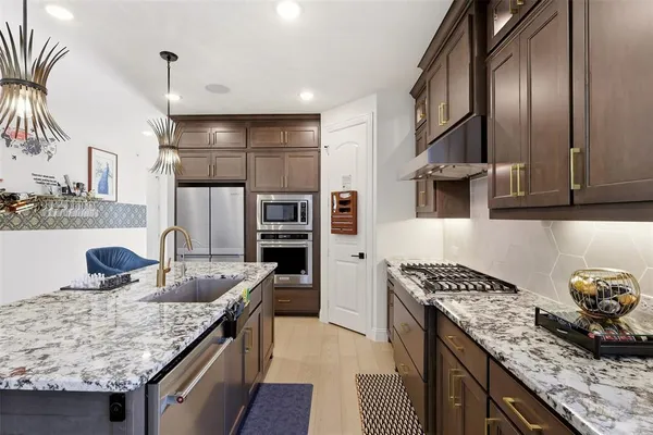 a kitchen with stainless steel appliances granite countertop a sink stove and refrigerator