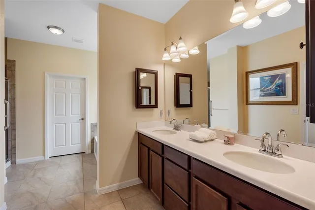 a bathroom with double vanity sinks a vanity a lamp and a mirror