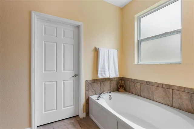 a bathroom with a tub and a window