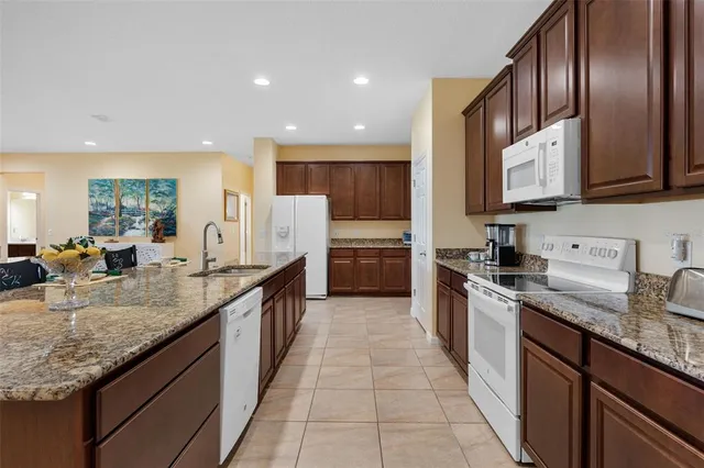 a large kitchen with stainless steel appliances granite countertop a sink counter space cabinets and a large window