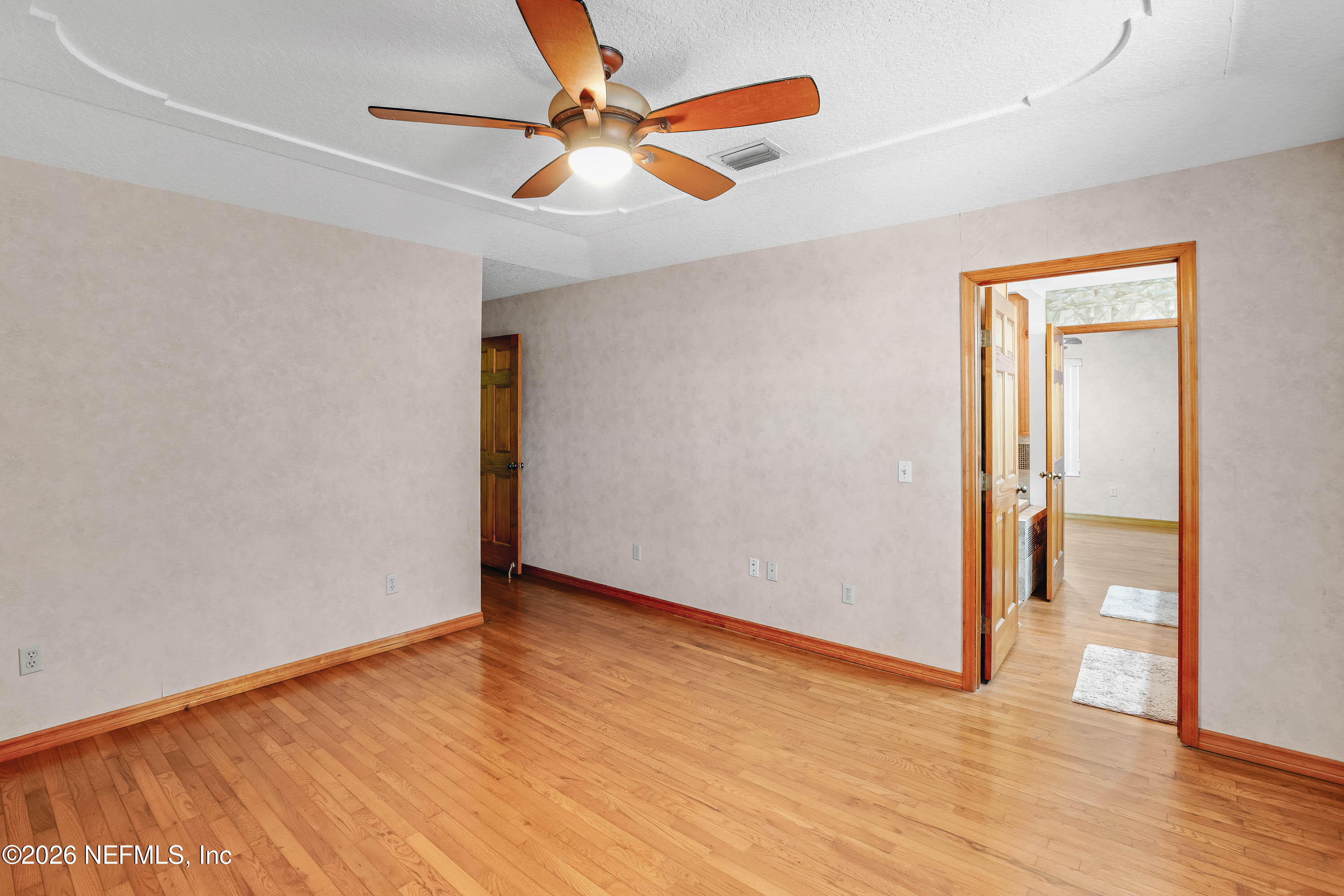 289 Chesser Road Interlachen, FL 32148 - Photo 26 of 63 an empty room with wooden floor and a ceiling fan