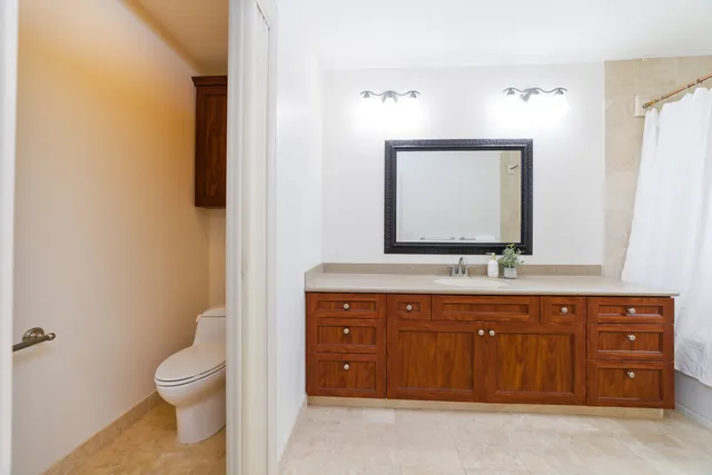 a large white kitchen with a white stove top oven a sink and a refrigerator