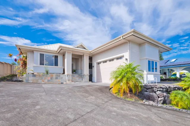 a view of a white house in front of a big yard