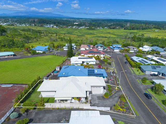 a front view of a house with a yard and potted plants