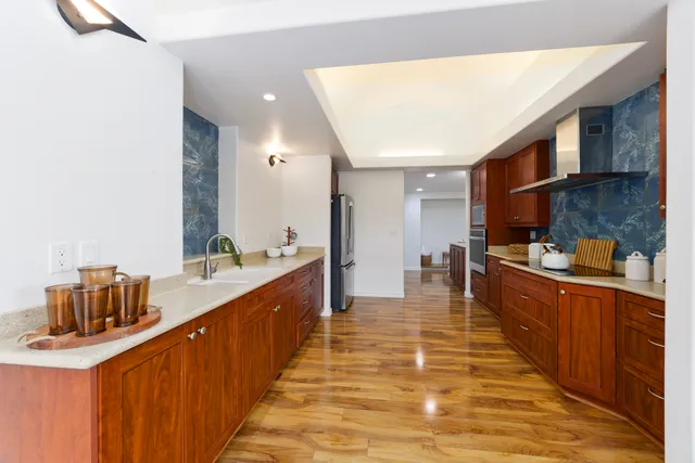 a kitchen with stainless steel appliances granite countertop a sink dishwasher stove and cabinets with wooden floor
