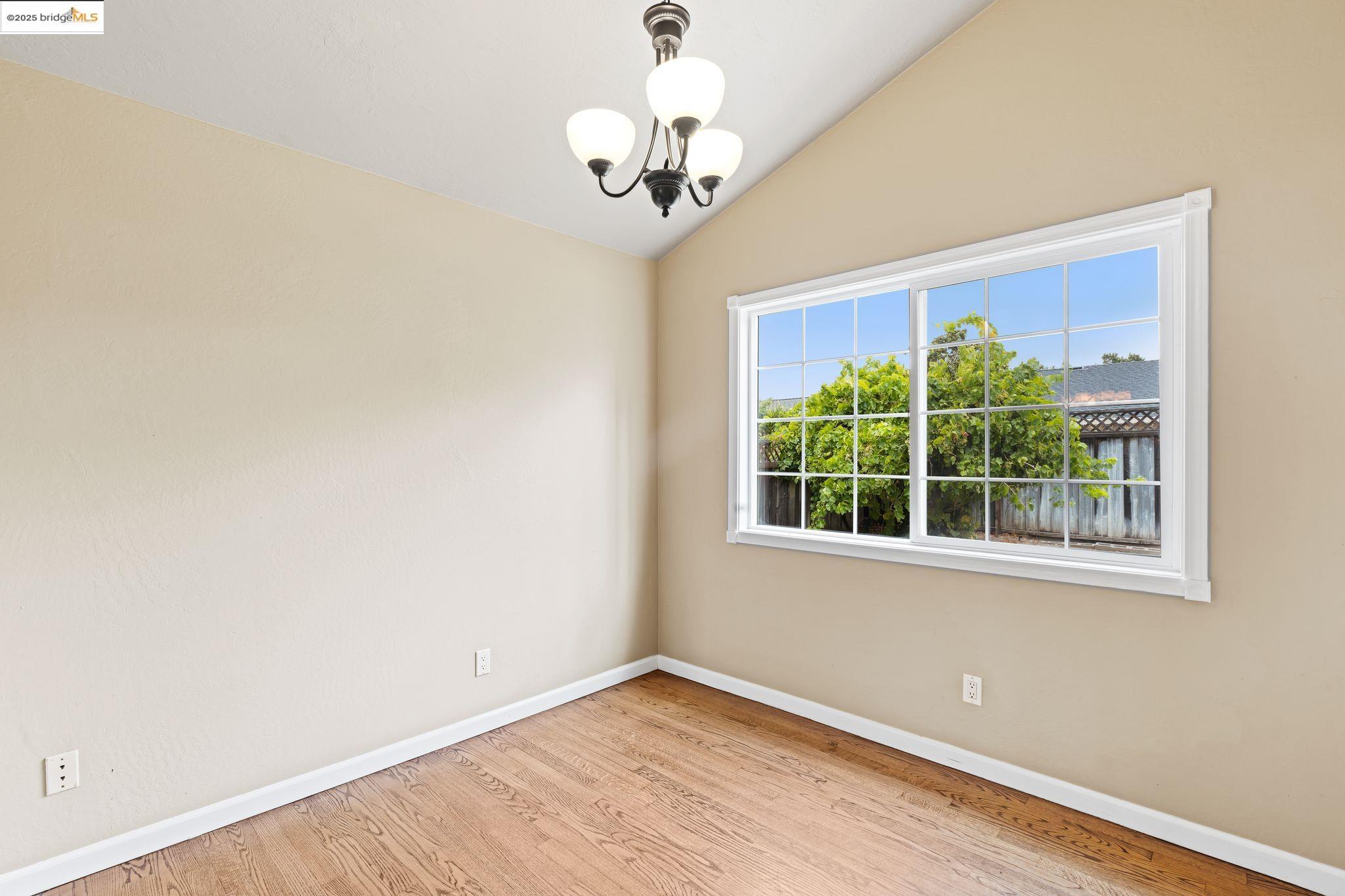 838 Hazel Street Livermore, CA 94550 - Photo 13 of 35 an empty room with wooden floor a chandelier fan and windows