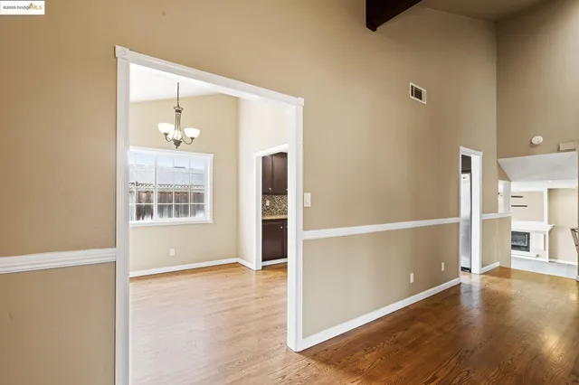 a view of a kitchen with a stove cabinets a ceiling fan and wooden floor