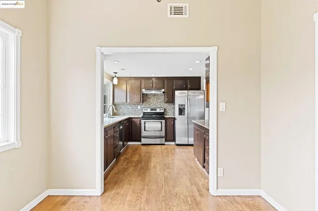 a kitchen with stainless steel appliances granite countertop a refrigerator and a sink