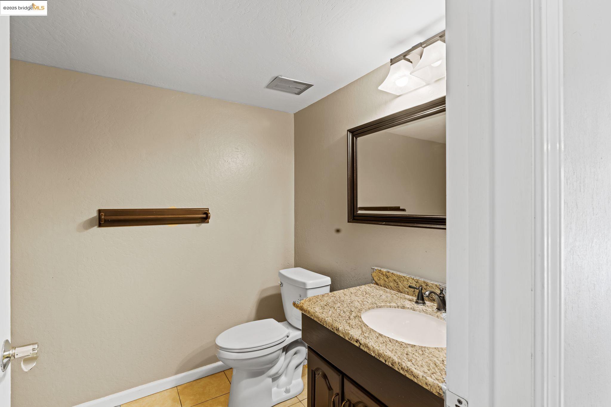 838 Hazel Street Livermore, CA 94550 - Photo 25 of 35 a bathroom with a granite countertop sink and a mirror