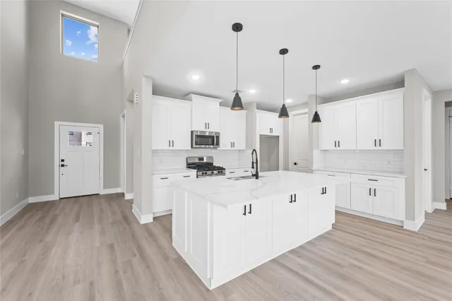 a large white kitchen with wooden floor